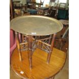 An eastern brass table on folding stand