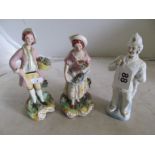 A pair of Staffordshire figures lady and gentleman with flowers (restored) and a bisque figure