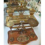 A brass inkstand with lyre centre and a set of brass postal scales on walnut base