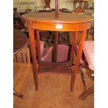An oval Edwardian inlaid mahogany table with lower shelf