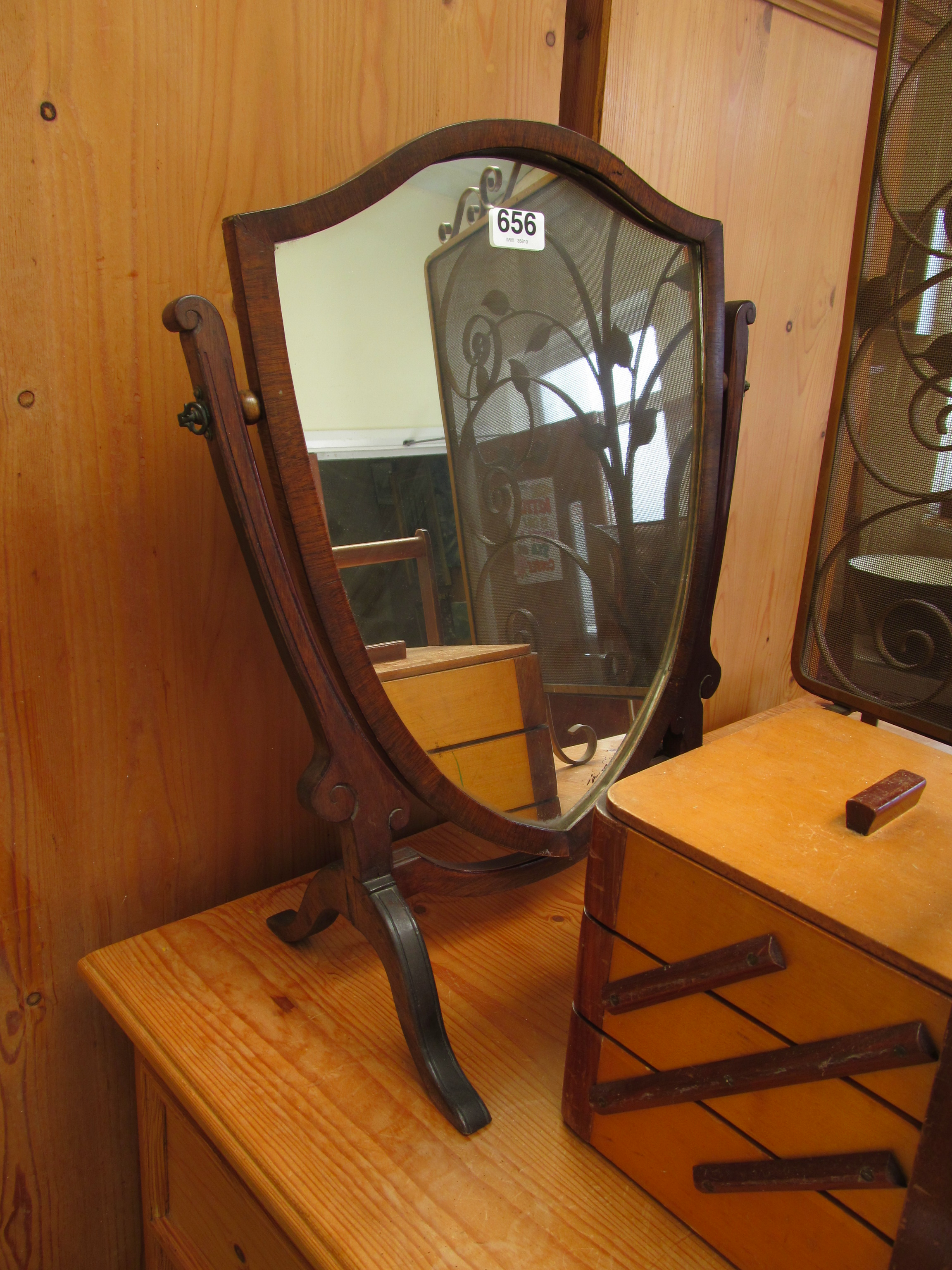 A shield shaped swing toilet mirror