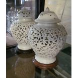 A pair of Oriental pierced lidded cream glazed vases flower and leaf design