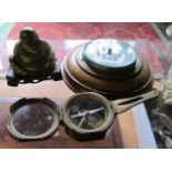 A circular barometer, brass Buddha and a compass