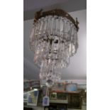 A three tier drop lustre ceiling light with gilt cherub rim