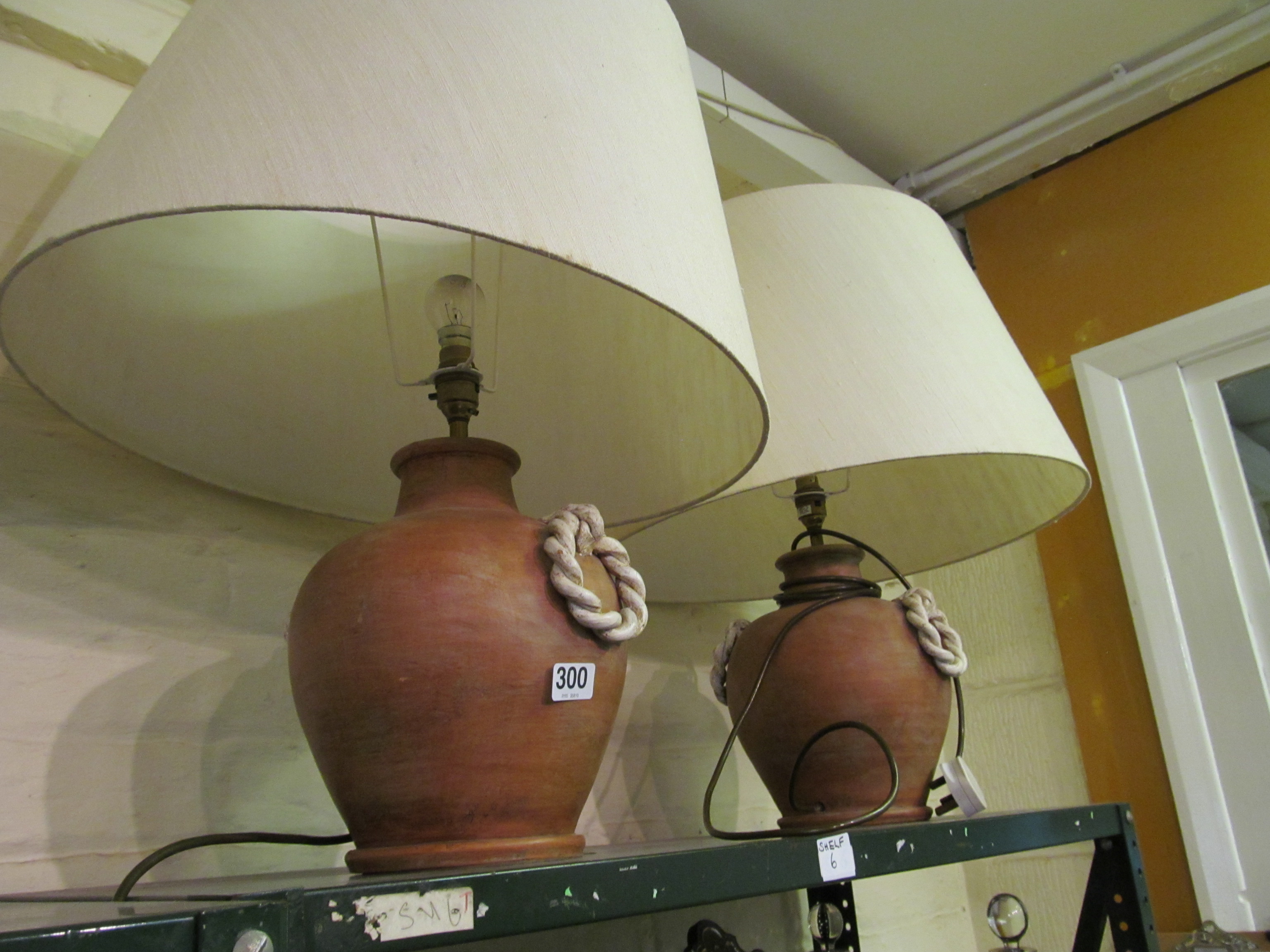 A pair of pottery lamps with ropetwist effect side handles and shades