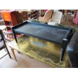 A low ebonised table on turned supports