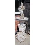 A large stoneware fountain with putti holding bird in bowl on a further column of putti on fish