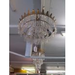 A four tier drop lustre chandelier with gilt leaf rim