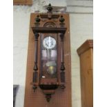 A 19th Century walnut Vienna style wall clock with finials to top, white dial and glass door