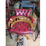 A red leather upholstered swivel captains chair