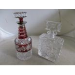 A cut glass square decanter and a Bohemia flash red and clear glass decanter.