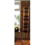 A retro floor standing lamp with strippy shade