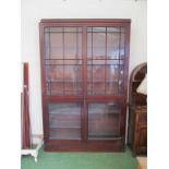 A tall two section mahogany bookcase with glazed doors
