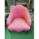 A Victorian chair upholstered in red on cabriole legs