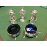 Two silver salts with blue glass liners, a pair of silver pepperettes and a silver egg shaped