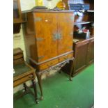 A walnut two door cocktail cabinet with fitted interior on cabriole legs