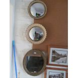 Two cream and gilt framed convex mirrors and a gilt oval mirror