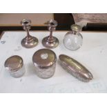 A pair of silver candlesticks, 3 silver lidded dressing table pots and a silver lidded glass