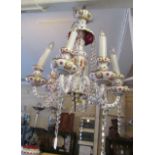 A red and white glass six branch chandelier decorated flowers
