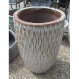 A tall turquoise and brown garden pot