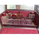 A ladies maroon leather travelling vanity case with lidded compartments and five glass and red