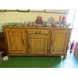 A large continental cherrywood? sideboard with central drawer and three cupboards.