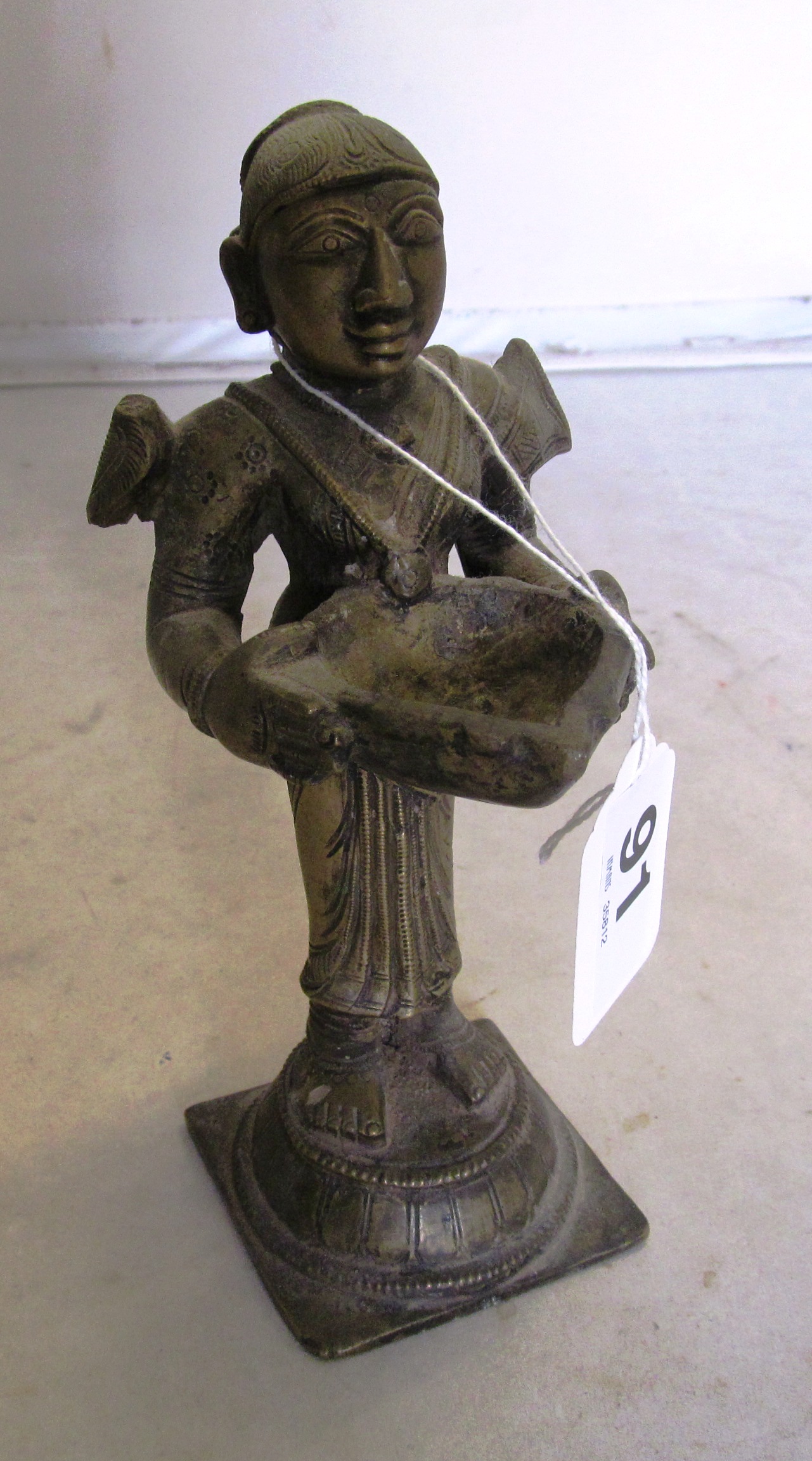 A bronze eastern figure deity holding a bowl