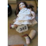 A 1920s google eyed doll, the bisque head with blue eyes and the body with bisque jointed limbs.