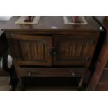 An oak cupboard with two linenfold doors