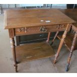 An Edwardian oak table with single drawer and undertier on fluted supports