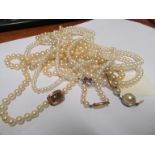 Four cultured pearl necklaces with gold clasps and a simulated pearl necklace