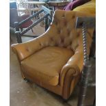 A brown leather button upholstered armchair