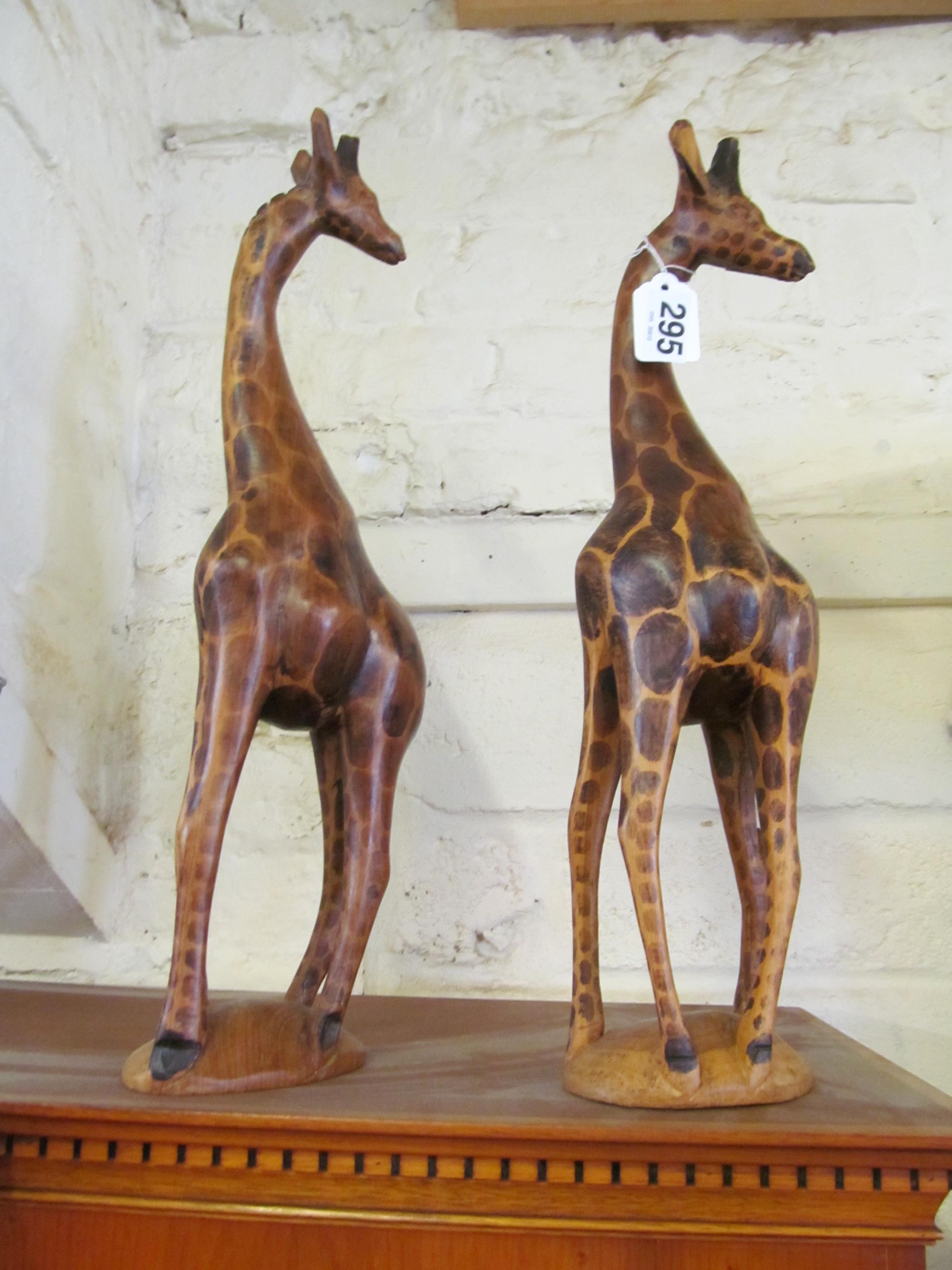 Two carved wood giraffe ornaments
