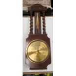 An oak barometer with brass dial