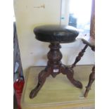 A Victorian swivel piano stool on tripod support