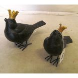 A pair of metal birds wearing crowns