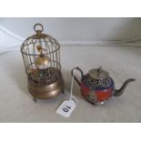 A small white metal and enamel Tibetan teapot and a bird cage clock