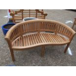 A bow shaped garden bench with cushion