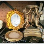 A gilt stand supported by three cherubs and for photograph frames
