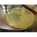 An eastern brass tray top table and and a brass tray