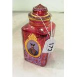 A red square scent bottle with stopper and portrait and bird