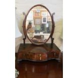 A 19th Century mahogany oval swing toilet mirror with crossbow front and three drawers
