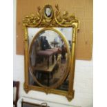 A gilt mirror with central oval and reserve of classical head and neoclassical cornice