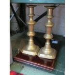 A pair brass candlesticks, other brass items and a small wooden shelf