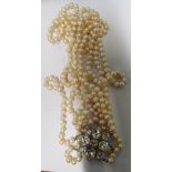 A cultured pearl triple necklace with large flowerhead clasp