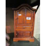 A small walnut cabinet in the form of an armoire with drawer and two cupboards