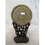 An oriental brass disc with scene of geisha in pagoda and garden on stand
