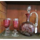 A red glass decanter and 2 glasses and another two glasses