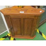 A small oak corner cabinet