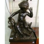 A large bronze figure cherub seated on a shell with hand pinched by a lobster